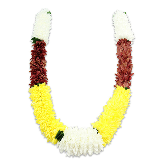 Seen against a bright white backdrop, this U-shaped floral garland is an exercise in colour-blocked tradition and careful craft: each arm opens with a dense, cylindrical cluster of creamy white, small, chrysanthemum-like fabric petals that feel plush to the eye. Beneath those white tops lies a shorter band of deep maroon - a reddish-brown assembled from tiny, layered synthetic blooms - which melts into the most prominent sweep of the piece: long, vibrant yellow petals designed to read like marigolds or miniature dahlias and to form the sweeping lower curve. Where the two yellow sections meet the garland closes with a lush central cluster of pure white blooms, broader than the top segments and serving as an intentional focal point. Dark green leaf-like pieces are placed sparingly between colour transitions, especially between yellow and the lower white cluster, providing a small but effective visual pause. The craftsmanship is obvious: thousands of fabric petals arranged with precise density, each row building volume and a tactile impression under soft studio lighting that casts a delicate shadow beneath the U. Intended for ceremonial use - Hindu pooja, temple offerings, weddings, Diwali or Holi celebrations - the colour choices speak to purity, prosperity and devotion while the artificial materials promise durability for repeated rites. As Florist Abbey Wood, preparing similar malas for deliveries across Abbey Wood and nearby Thamesmead or for processions near Abbey Wood station, we choose this construction when customers want traditional symbolism married to robust, long-lasting design.