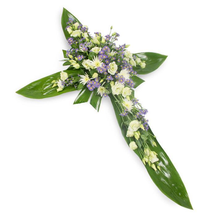 Viewed from a soft overhead angle on a stark white backdrop, this floral cross reads as a composed gesture of comfort and faith. The cross's framework is formed from overlapping, vibrant green tropical leaves - their glossy sheen and clear venation giving the piece a robust, living foundation - while the floral composition sits primarily at the centre and extends along each arm. Creamy, soft-white lisianthus with their multi-layered, ruffled petals create an elegant, almost pillow-like mass; interspersed among them are smaller rounded white chrysanthemums or similar sprays that brighten the arrangement with concentrated points of light. Sprays of tiny lavender-hued limonium or asters bring a cool, muted counterpoint, sprinkling the design with delicate purple notes that suggest calm and remembrance. Slender, fine foliage acts as gentle filler, weaving a naturalistic texture through the blooms and softening the transition from flower to leaf. The studio-like lighting renders the colours true and the textures tactile - the leaves' smooth, waxy resilience against the blooms' tender translucence - producing an atmosphere of quiet reverence. This cross is the sort of memorial arrangement commonly used at services, wakes or church displays, conveying sympathy and a measured hopefulness. For families in Abbey Wood and neighbouring streets I design pieces like this to reflect tranquillity and respect, making sure they arrive with fresh blooms and meticulous balance so the tribute can speak plainly and tenderly at a difficult time.