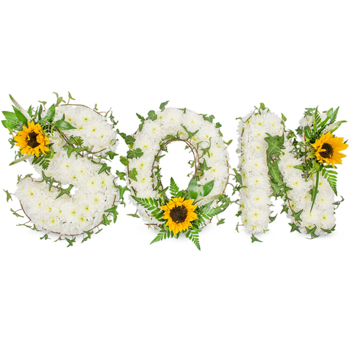 A bespoke memorial display spells out 'SON' in capital letters, each character formed from a dense mass of small, pure white chrysanthemums whose fine petals create a soft, pillowed surface that feels both delicate and substantial. Dark green ivy vines are artfully interlaced through the three letters, their glossy foliage and trailing lines adding depth and a living, evergreen symbolism of continuity; additional fern fronds and assorted green leaves introduce texture contrasts and gentle movement so the letters retain a sculpted, three-dimensional presence. Placed to draw the eye, three large sunflowers with bright yellow petals and prominent dark brown centers bring warmth and visual punctuation: one is set into the upper-left sweep of the 'S', another nestles at the bottom centre of the 'O' among verdant fronds, and the third adorns the upper-right stroke of the 'N'. Photographed on a stark white background beneath soft, diffuse light, the composition reads with clarity and quiet dignity - every petal, vein and shadow is visible, emphasising the craftsmanship. The combination of pristine white, deep green and sunny yellow offers a comforting contrast that speaks of purity, life and hopeful memory. Local families in Abbey Wood, near Abbey Wood station and the green spaces by Lesnes Abbey Woods and Thamesmead, often choose this gentle, word-based tribute to honour a son - a composed, tactile expression of sorrow, respect and ongoing affection.